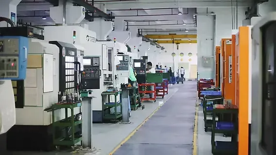 A long aisle of machining centers and workbenches inside a commercial machine shop building