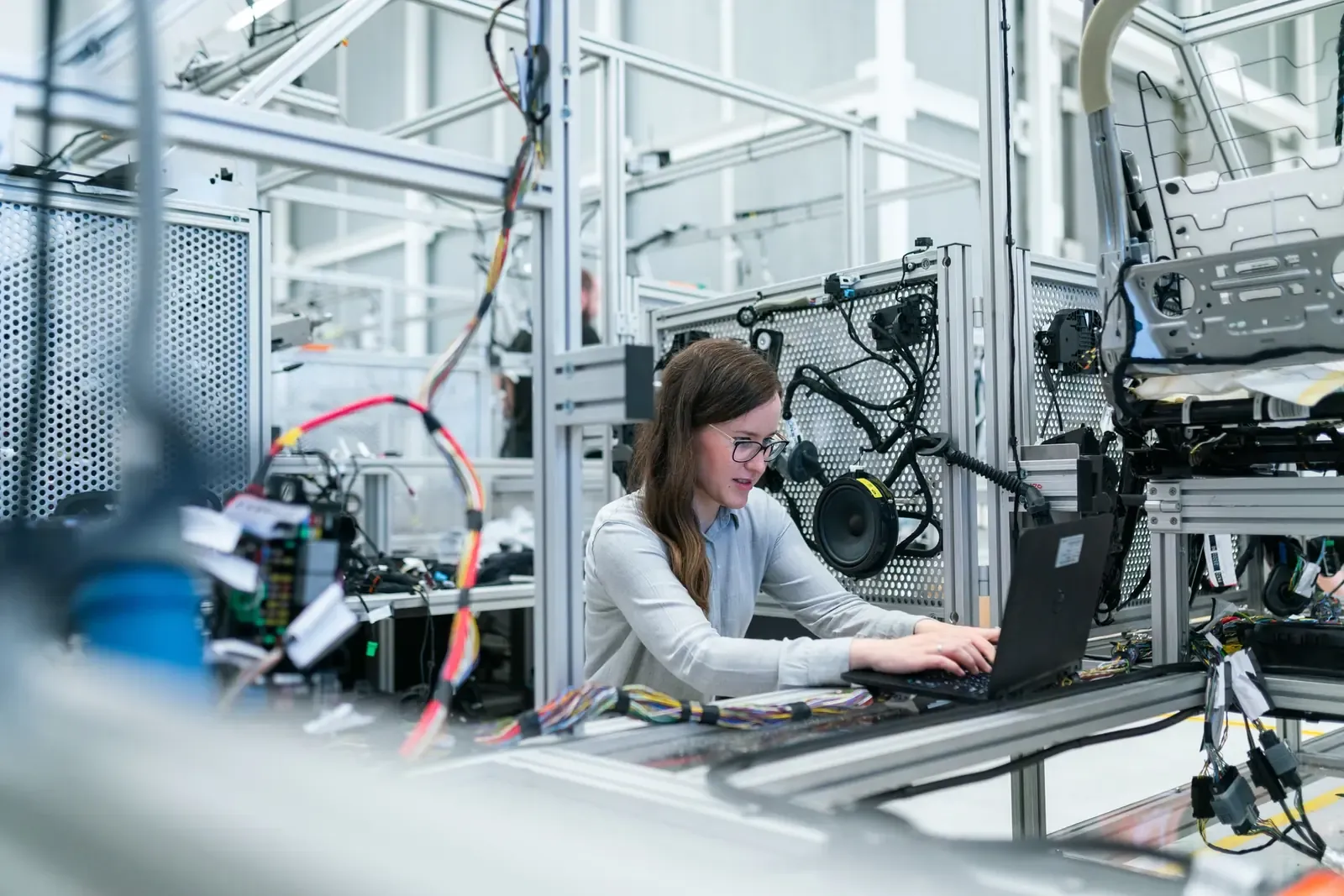 A technician working on a laptop beside an automated assembly station — machine shop and manufacturing insurance in Idaho