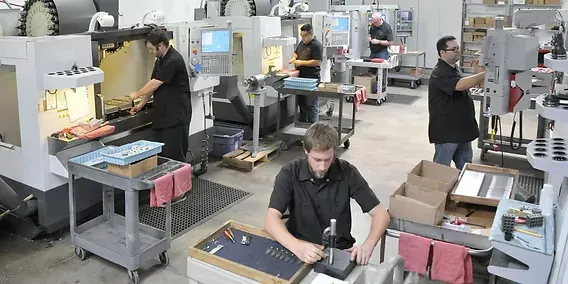 Machinists running parts at workstations and machining centers in a busy job shop — machine shop and manufacturing insurance in Minnesota