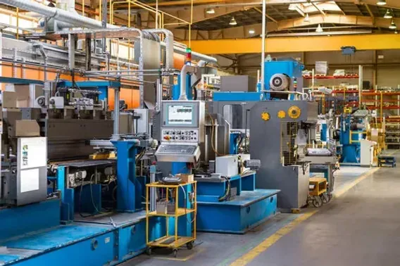 A row of CNC machining centers and production equipment arranged along a manufacturing shop floor