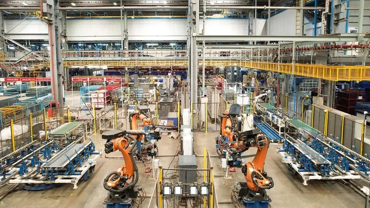 Robotic arms and conveyor lines running down the floor of an automated manufacturing plant
