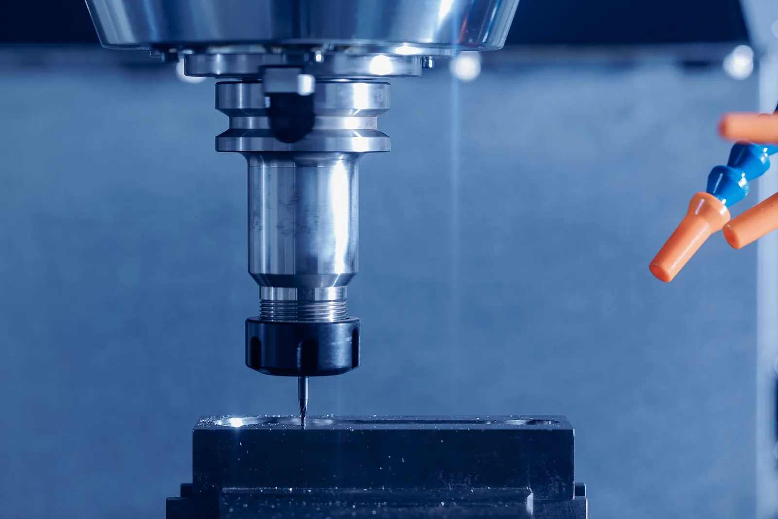 A cutting tool in a machine spindle poised above a workpiece held in a vise