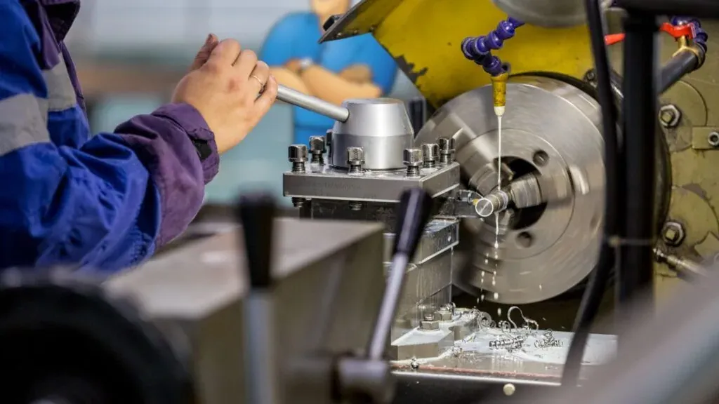 A metal part held in a lathe chuck during a precision turning operation — machine shop and manufacturing insurance in Iowa